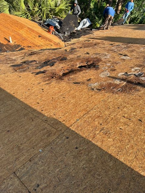 EZ Roofing crew tearing off old roof decking during a reroof job